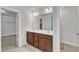 Double sink bathroom featuring a neutral color scheme, brown vanity, and a separate room with closet at 3413 Fairstone Rd, Wake Forest, NC 27587