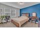 Cozy bedroom with a large window, blue accent wall, and comfortable furniture, creating a relaxing and inviting atmosphere at 3413 Fairstone Rd, Wake Forest, NC 27587