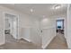 Hallway with neutral colored walls, carpet, and two open doors to other rooms at 3413 Fairstone Rd, Wake Forest, NC 27587
