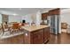 Spacious kitchen island features granite countertops, dark wood cabinets, and an open floorplan to the living and dining areas at 3413 Fairstone Rd, Wake Forest, NC 27587