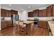 Modern kitchen boasts stainless steel appliances, granite countertops, dark wood cabinets and a convenient center island with bar stools at 3413 Fairstone Rd, Wake Forest, NC 27587
