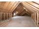 Unfinished attic featuring exposed wood beams and rafters, offering potential for customization at 3417 Aspen Rd, Rocky Mount, NC 27804