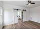 Bright bathroom with hardwood floors, sliding barn doors, standalone tub and fan at 3417 Aspen Rd, Rocky Mount, NC 27804