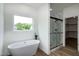 Bathroom featuring a freestanding tub, glass shower, and closet access at 3417 Aspen Rd, Rocky Mount, NC 27804