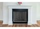 Close-up of the fireplace featuring a white mantle and black metal screen, complemented by wood-look flooring at 3417 Aspen Rd, Rocky Mount, NC 27804