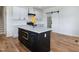 Modern kitchen showcasing white cabinetry, stainless steel appliances, hardwood floors, and a dark kitchen island at 3417 Aspen Rd, Rocky Mount, NC 27804