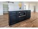 Kitchen island with storage, microwave, seating space and views of the pantry, stairs and open living space at 3417 Aspen Rd, Rocky Mount, NC 27804