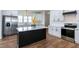 Well-lit kitchen featuring white cabinets, stainless steel appliances, a dark island, and hardwood floors at 3417 Aspen Rd, Rocky Mount, NC 27804