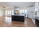 Open-concept living space flowing into a modern kitchen with white cabinetry, a dark island, and stainless steel appliances at 3417 Aspen Rd, Rocky Mount, NC 27804