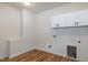 Laundry room with white walls, hardwood floors, and cabinets above the washer and dryer hookups at 3417 Aspen Rd, Rocky Mount, NC 27804