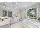 Bright bathroom featuring a garden tub, white cabinets, stone countertops and large window at 4109 City Of Oaks Wynd, Raleigh, NC 27612