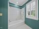 Bathroom tub and shower featuring white tile, and a large window with shutter blinds at 4109 City Of Oaks Wynd, Raleigh, NC 27612