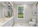 Elegant bathroom features a large window, white cabinets, and modern fixtures at 4109 City Of Oaks Wynd, Raleigh, NC 27612