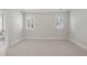 Bright bedroom features neutral carpet, trim, and wall paint, with natural light from two shuttered windows at 4109 City Of Oaks Wynd, Raleigh, NC 27612