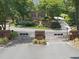 Gated entrance to 'The Thistleburgh' community with mature landscaping and brick pillars and walls at 4109 City Of Oaks Wynd, Raleigh, NC 27612