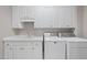 Well-equipped laundry room with storage cabinets, sink, washer, and dryer at 4109 City Of Oaks Wynd, Raleigh, NC 27612
