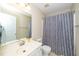 Standard bathroom with neutral walls, white sink vanity and a shower with patterned curtain at 4114 Brenmar Ln, Durham, NC 27713