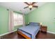 Simple bedroom with a ceiling fan, hardwood floors, and a large window at 4114 Brenmar Ln, Durham, NC 27713