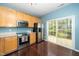 Cozy kitchen featuring stainless steel appliances, wood cabinets, and sliding glass doors to the backyard at 4114 Brenmar Ln, Durham, NC 27713