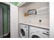 Laundry room with washer, dryer, storage shelves and white bi-fold doors at 4114 Brenmar Ln, Durham, NC 27713