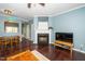 Living room featuring a fireplace, hardwood floors, and a view into the dining space at 4114 Brenmar Ln, Durham, NC 27713