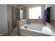 Bright bathroom with a walk-in shower, soaking tub and large window offering natural light at 412 Ashdale Dr, Fuquay Varina, NC 27526