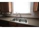 Close-up of the kitchen sink area with stainless steel sink, tile backsplash, and bright window at 412 Ashdale Dr, Fuquay Varina, NC 27526