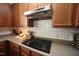 Close-up of the modern gas stovetop with a sleek range hood and tile backsplash at 412 Ashdale Dr, Fuquay Varina, NC 27526