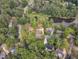 An aerial view capturing a neighborhood with a lake and homes surrounded by dense, mature trees at 4504 Ryegate Dr, Raleigh, NC 27604