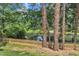 Backyard view with picket fence bordering the pond and mature trees providing shade at 4504 Ryegate Dr, Raleigh, NC 27604