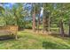 Large backyard featuring wood deck, picket fence, mature trees and a serene pond at 4504 Ryegate Dr, Raleigh, NC 27604
