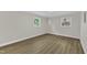 Bright bedroom featuring light-colored walls, wood floors, white trim, and natural light from two windows at 4504 Ryegate Dr, Raleigh, NC 27604
