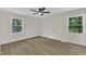 Bright bedroom features hardwood floors, two windows, and neutral paint at 4504 Ryegate Dr, Raleigh, NC 27604