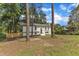 Attractive two-story white brick home with a green lawn and mature trees, showcasing a serene neighborhood at 4504 Ryegate Dr, Raleigh, NC 27604