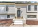 Close up of a lovely home's entrance, showcasing a decorative front door, white brick, and trimmed plants at 4504 Ryegate Dr, Raleigh, NC 27604
