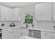 A stainless steel dishwasher complements the white cabinets, quartz counters and subway tile at 4504 Ryegate Dr, Raleigh, NC 27604