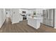 Modern kitchen with white cabinets, stainless steel appliances, island, and wood-look floors at 4504 Ryegate Dr, Raleigh, NC 27604