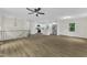 Open-concept living room with a modern ceiling fan, updated kitchen, and wood-look flooring at 4504 Ryegate Dr, Raleigh, NC 27604