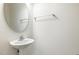 A well-lit half bathroom features a pedestal sink and a stylish oval mirror at 5031 Eagle Stone Ln, Raleigh, NC 27610