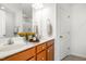 A bright bathroom featuring a double sink vanity with wooden cabinets, a large mirror, and fresh flowers at 5031 Eagle Stone Ln, Raleigh, NC 27610