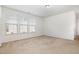 Bright bedroom with neutral carpet, three windows, and white walls at 5031 Eagle Stone Ln, Raleigh, NC 27610