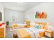 Bright bedroom featuring two beds, colorful shelves, and a window that provides natural light at 5031 Eagle Stone Ln, Raleigh, NC 27610