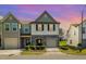 Charming two-story townhouse with a stone facade and attached garage during sunset at 5031 Eagle Stone Ln, Raleigh, NC 27610