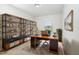 Functional office featuring a wooden desk, ample shelving, and a large window for natural light at 5031 Eagle Stone Ln, Raleigh, NC 27610