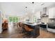 Open kitchen and living area with stainless steel appliances, modern island, and hardwood floors at 515 N Churton St # Ste 201, Hillsborough, NC 27278