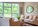Bright living room with an oversized couch, view of the lush green trees outside the large window at 515 N Churton St # Ste 201, Hillsborough, NC 27278