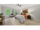 Comfortable bedroom with a ceiling fan, cozy rug, and bright windows overlooking lush trees at 5315 Fortunes Ridge Dr, Durham, NC 27713