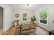 Sunlit dining room features a glass table with seating for six, a bar cart, and natural lighting at 5315 Fortunes Ridge Dr, Durham, NC 27713