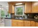 Kitchen with wooden cabinets, dark countertops, stainless steel sink, and scenic window overlooking greenery at 5315 Fortunes Ridge Dr, Durham, NC 27713