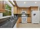 Well-maintained kitchen featuring wooden cabinets, granite countertops, tile backsplash, and modern appliances at 5315 Fortunes Ridge Dr, Durham, NC 27713